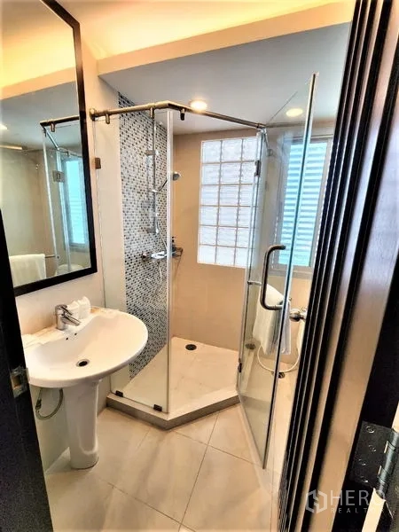 Condominium for rent in Bang Rak, Bangkok - Bright second bedroom with king bed, orange cushions, TV console, wardrobes, large windows and wooden floors.