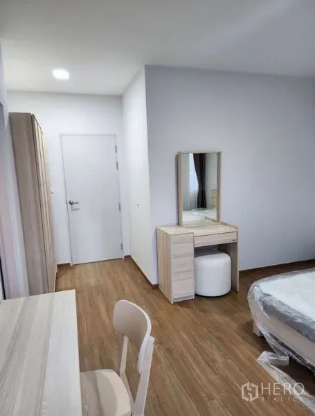 Townhouse for rent in Bang Phli, Samut Prakan - Bright bedroom with wood floors, wardrobe, dressing table, and study desk.