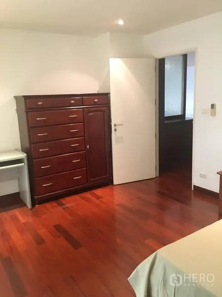 公寓 出租或出售在Watthana, Bangkok - 卧室配高大木质五斗柜，木地板与嵌灯。