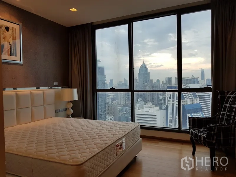 Condominium for rent in Watthana, Bangkok - Master bedroom with large window and panoramic Bangkok skyline