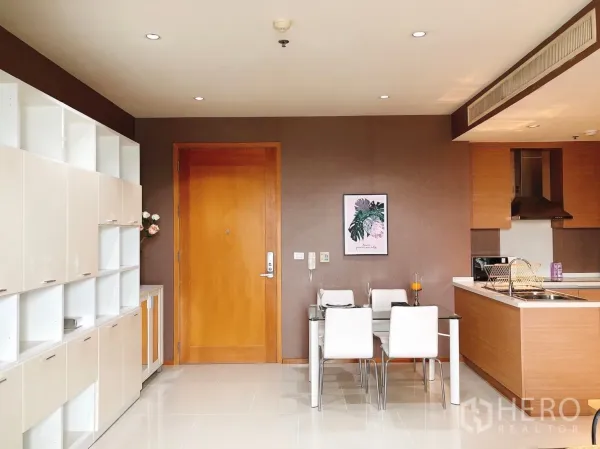 Condominium for rent in Khlong Toei, Bangkok - Open-plan entry with a four-seat dining table and kitchen peninsula.