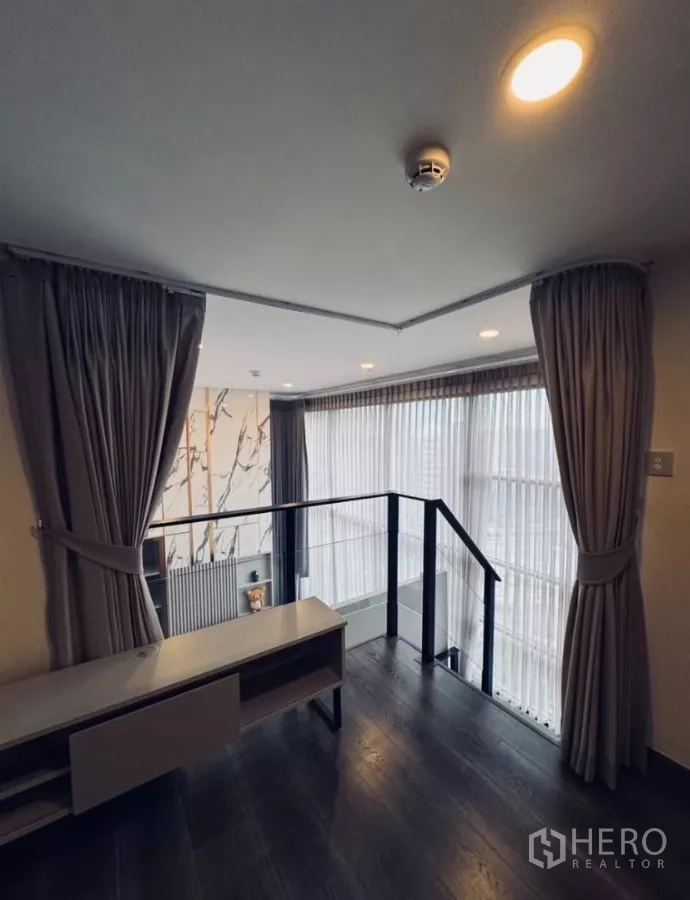 公寓 出租在Chatuchak, Bangkok - 开放夹层空间，栏杆与窗帘，俯视客厅。