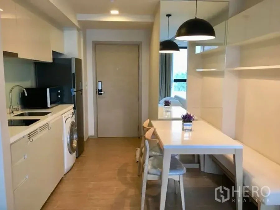 公寓 出租或出售在Watthana, Bangkok - 现代公寓厨房与用餐区，内置橱柜、洗衣机与吊灯
