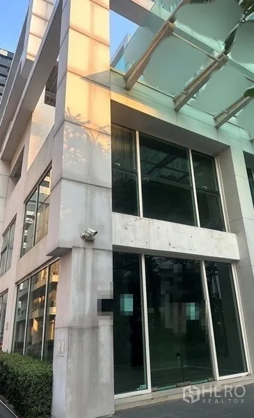 Retail Space for rent in Huai Khwang, Bangkok - Modern low-rise building exterior with double-height glass storefront and canopy.