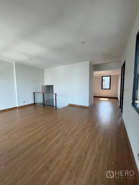 Townhouse for rent - Open-plan family room with wood flooring and corridor to bedrooms.
