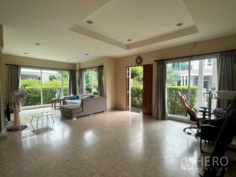 独立式住宅 出售在Saphan Sung, Bangkok - 开放式客厅，沙发与大窗，景观面向花园。