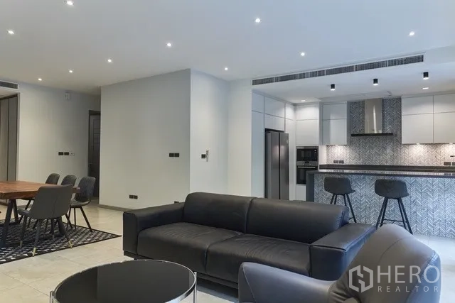 Townhouse for sale in Watthana, Bangkok - Open-plan lounge with recessed lighting and views toward the modern kitchen.