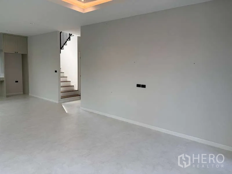 独立式住宅 出租或出售在Bang Phli, Samut Prakan - 采光充足的开放式客厅，吊顶氛围灯与中性色地面。