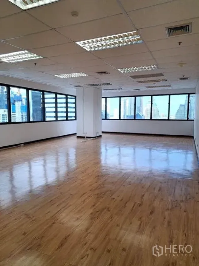 Office Space for rent in Bang Rak, Bangkok - Large open office area with multiple windows, polished wood-look floors and city views.