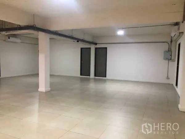 Office Space for rent in Phaya Thai, Bangkok - Open-plan 115 sqm office interior with tiled floors, white walls, exposed ceiling and two doors in Phaya Thai.