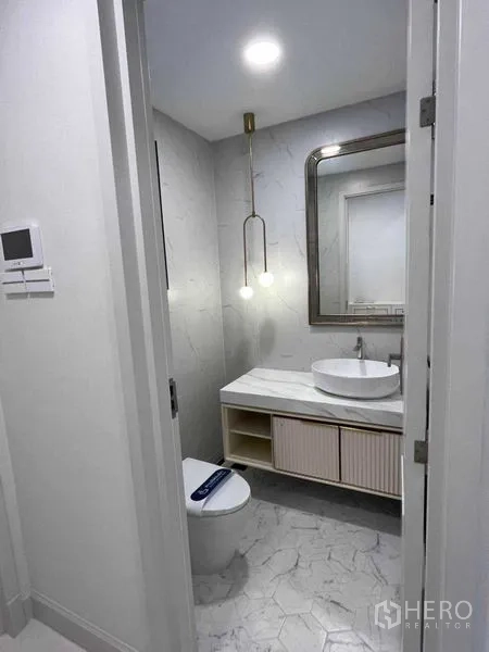 Detached House for rent in Saphan Sung, Bangkok - Guest bathroom with pendant light, marble vanity and modern toilet.