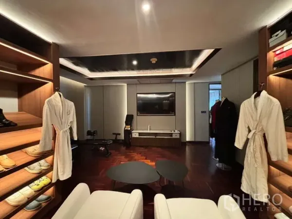 Condominium for rent in Watthana, Bangkok - Large walk-in closet and lounge with open shelving, TV and small gym equipment.