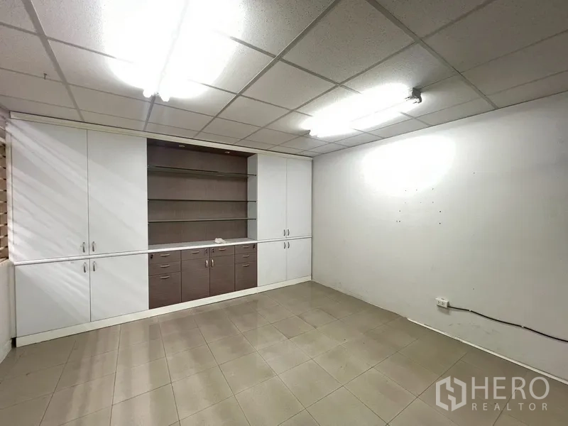 Shophouse for rent in Phra Khanong, Bangkok - Office room with built-in wall cabinets and shelving.