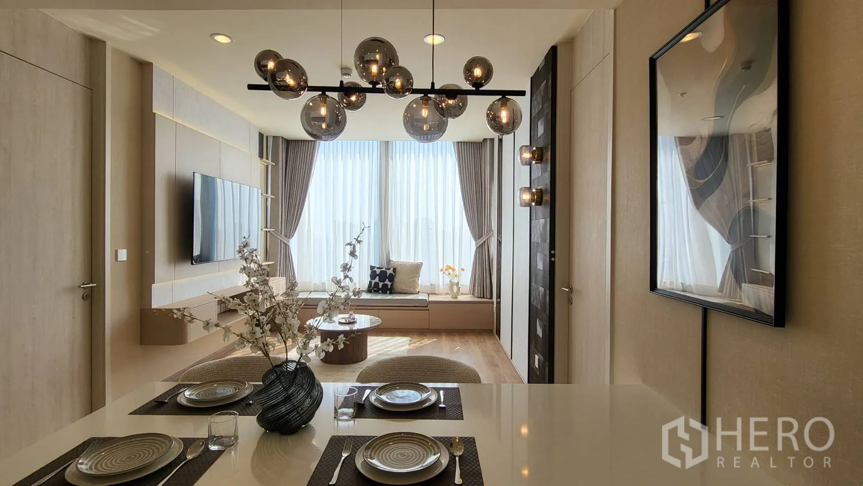 公寓 for sale in Watthana, Bangkok - 开放式客餐厅，球形吊灯、壁挂电视、落地窗与窗边长凳。