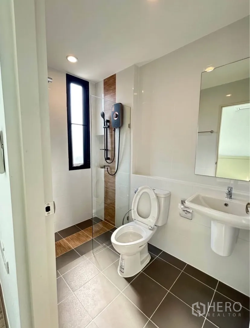 Semi-detached House for rent in Bang Phli, Samut Prakan - Modern bathroom featuring a glass-enclosed shower with water heater, toilet and wall-mounted sink.