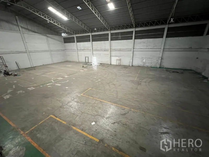 货栈 出租在Bang Sao Thong, Samut Prakan - 仓库开阔地面，标线清晰，位于桁架屋顶下。