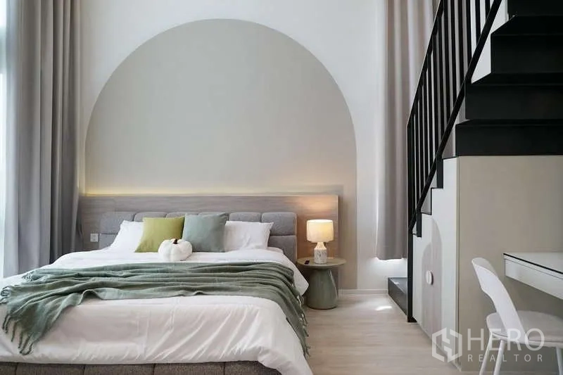 Detached House for rent in Saphan Sung, Bangkok - Bedroom with arched feature wall, high ceiling and stairs to a loft space.