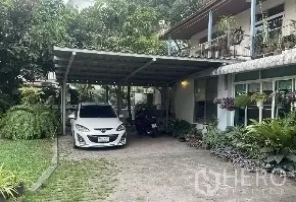 Detached House for rent in Watthana, Bangkok - Two-storey detached house with a covered carport, wide driveway and lush tropical garden.