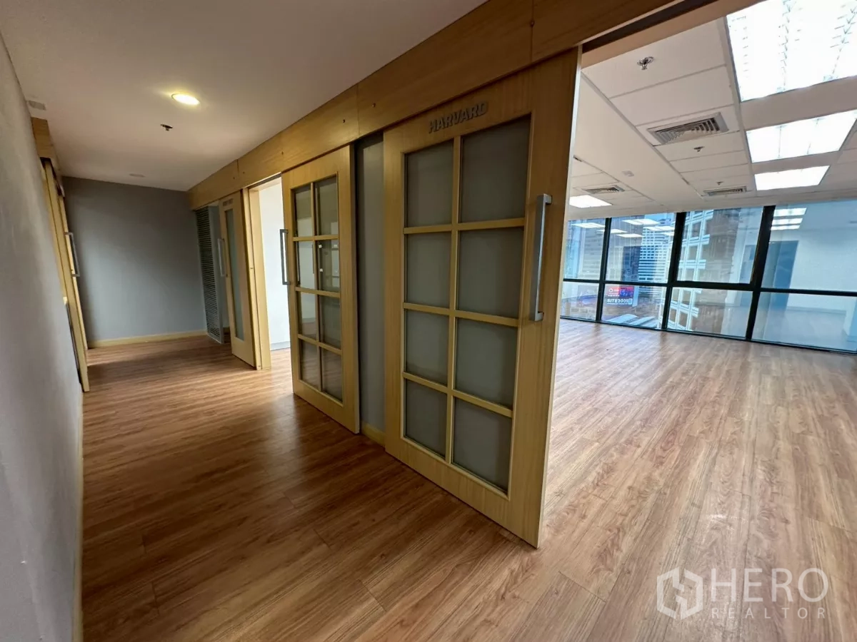 Office Space for rent in Khlong Toei, Bangkok - Hallway with sliding wooden doors opening to a bright corner office.