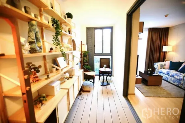 公寓 出租或出售在Watthana, Bangkok - 封闭式阳光房，木质置物架与绿植，小型休闲桌椅靠窗，与客厅相连。