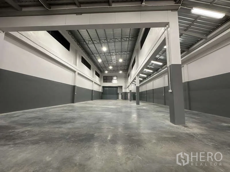 Factory for rent or sale in Bang Bua Thong, Nonthaburi - Wide warehouse span with central columns and bright LED lighting.