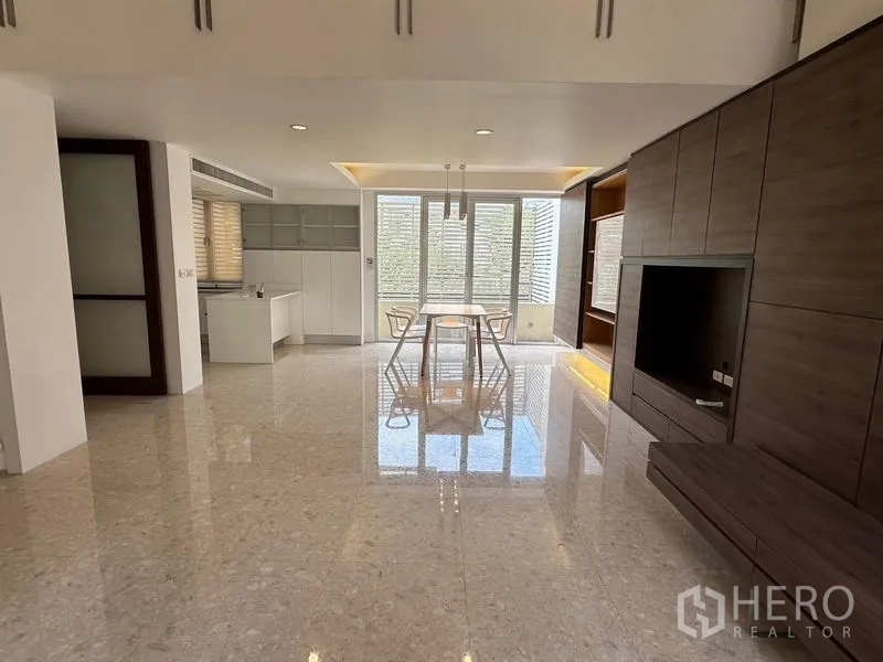Townhouse for sale in Yan Nawa, Bangkok - Open-plan living and dining area with glossy stone floor, large windows and built-in wall cabinetry.