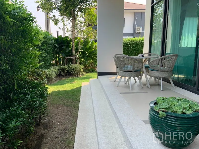 Detached House for rent or sale in Bang Kapi, Bangkok - Shaded terrace with outdoor seating beside a small landscaped garden.
