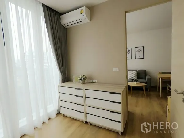 Condominium for rent or sale in Khlong Toei, Bangkok - Bedroom corner with dresser, air conditioner, and doorway leading to the living area.