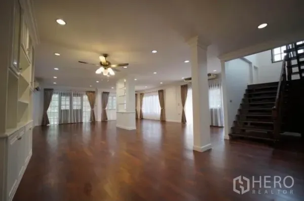บ้าน ให้เช่าในBang Phli, Samut Prakan - พื้นที่รับแขกแบบเปิดโล่ง ปูพื้นไม้ ฝ้าไฟดาวน์ไลท์ และบันไดไม้