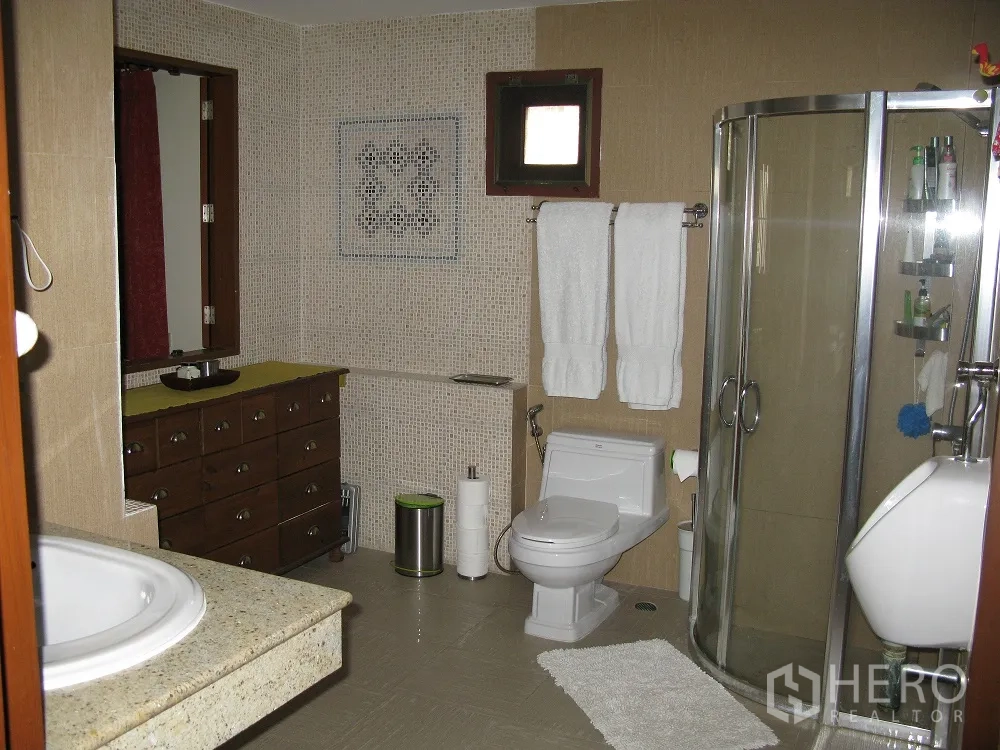 Townhouse for rent or sale in Watthana, Bangkok - Spacious bathroom with glass corner shower, vanity and mosaic-tiled walls.