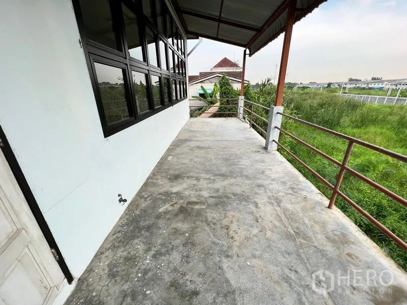 货栈 出租在Min Buri, Bangkok - 室外露台阳台，带扶手，俯瞰仓库旁的绿地。
