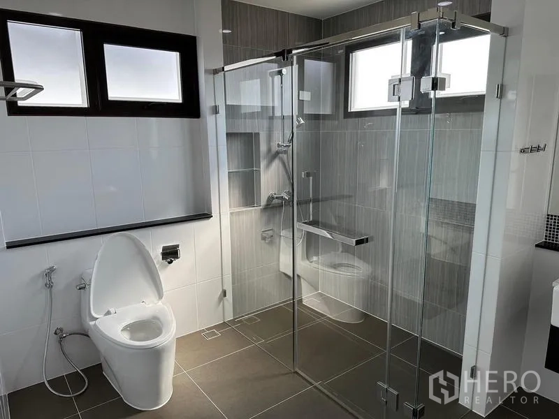 Detached House for sale in Saphan Sung, Bangkok - Contemporary bathroom with glass shower enclosure and toilet.