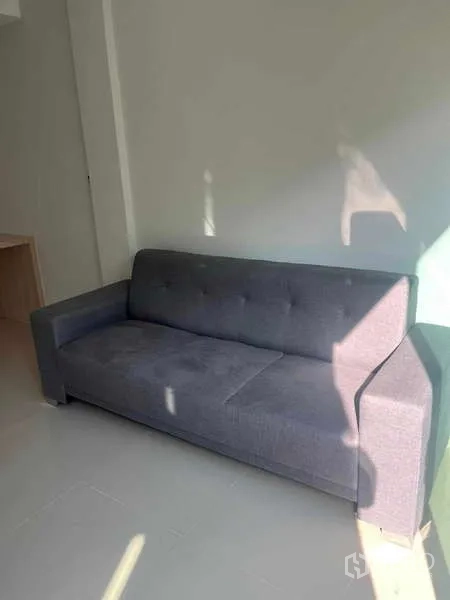Townhouse for rent in Suan Luang, Bangkok - Bright living corner featuring a gray fabric sofa against a light-painted wall.