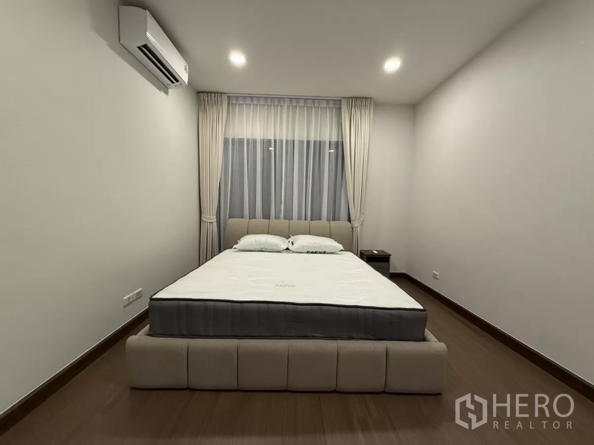 独立式住宅 出租在Bang Phli, Samut Prakan - 极简卧室，双人床、空调与纱帘。