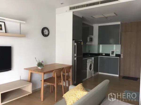 公寓 出租或出售在Bangkok - 素坤逸澎蓬站附近的现代公寓：开放式客餐厅，L形厨房配冰箱、微波炉与洗衣机。