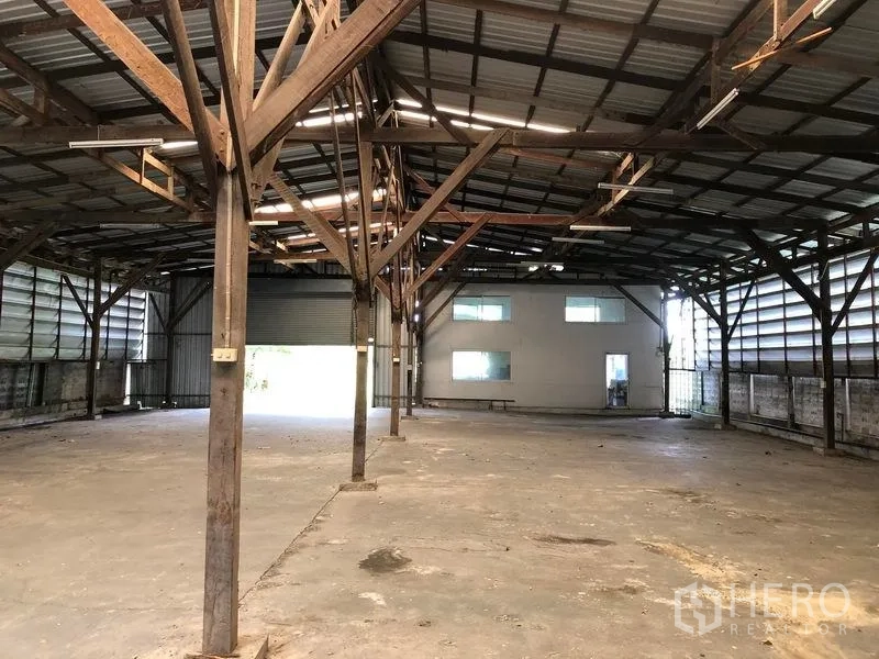 Warehouse for rent in Bang Bua Thong, Nonthaburi - Open-plan warehouse showing internal office block, steel structure and large loading door for trucks.