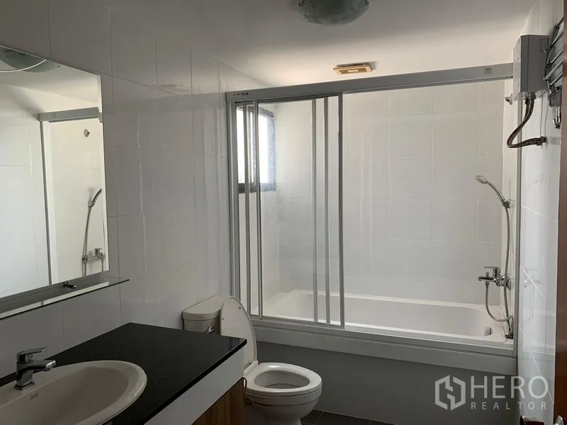 公寓 出租或出售在Watthana, Bangkok - 浴室配浴缸与推拉玻璃隔断、花洒及宽台盆。