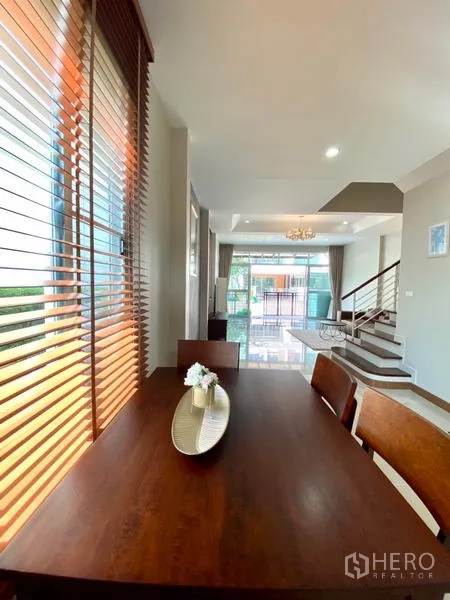 Townhouse for rent in Prawet, Bangkok - View from dining table across open-plan living area to front sliding doors and staircase.