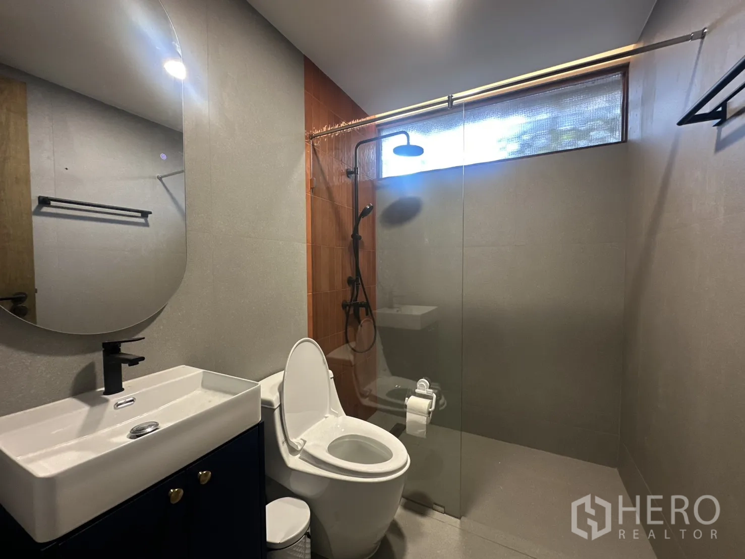 พื้นที่ขายของ for rent in Watthana, Bangkok - ห้องน้ำสมัยใหม่พร้อมตู้กระจกกั้นอาบน้ำและกระจกทรงกลม.