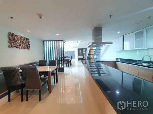 คอนโด ให้เช่าในRatchathewi, Bangkok - พื้นที่รับประทานอาหารแบบเปิดเชื่อมครัวสมัยใหม่ เคาน์เตอร์หินแกรนิตสีดำยาว ตู้ลายไม้ และพื้นกระเบื้องมันวาว.