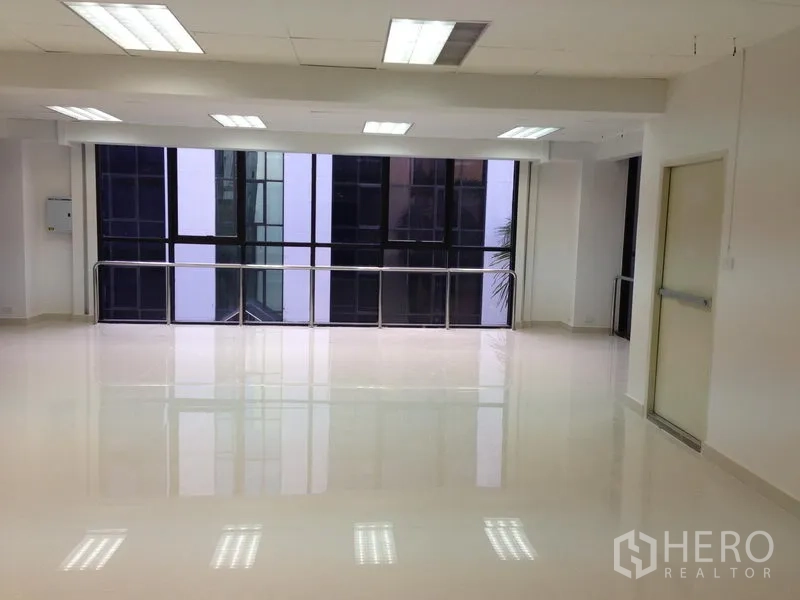 Office Space for rent in Bang Kapi, Bangkok - Open office room with shiny tiled flooring, wide windows and stainless safety rail under bright lights.