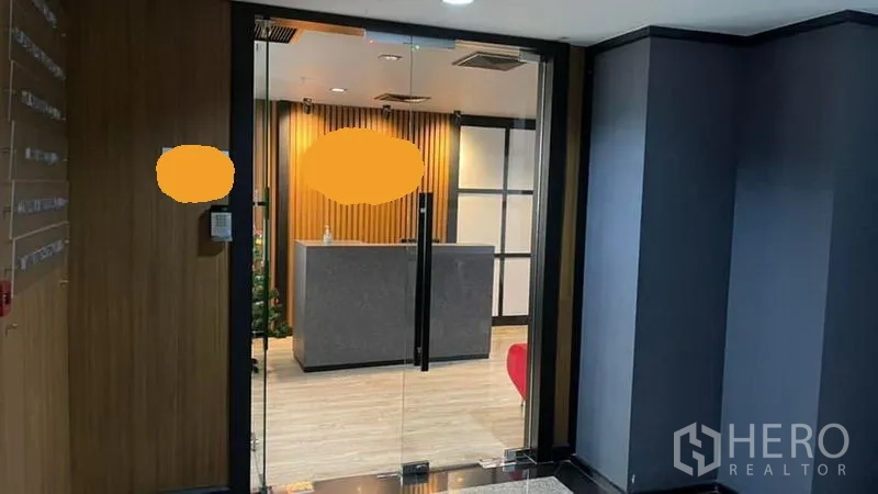 Office Space for rent in Khlong Toei, Bangkok - Glass-door office entrance leading to a reception area with a wood accent wall.