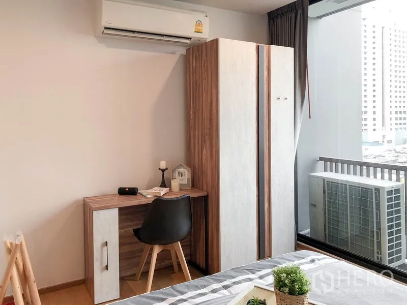 公寓 出租在Bang Rak, Bangkok - 紧凑书桌与衣柜位于空调下，靠近阳台窗。