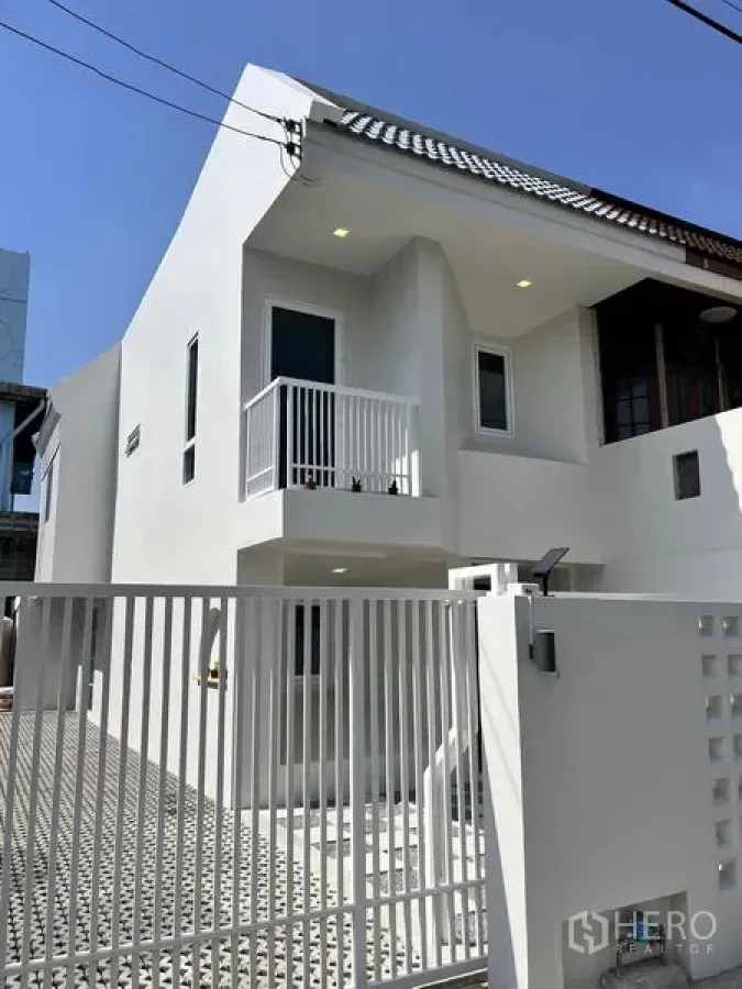 Townhouse for sale in Phra Khanong, Bangkok - Fresh white townhouse exterior with gated entry and small balcony in Phra Khanong.