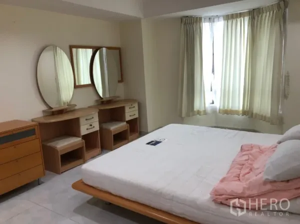 Condominium for rent in Watthana, Bangkok - Bedroom with bay window, twin vanities and a double bed.