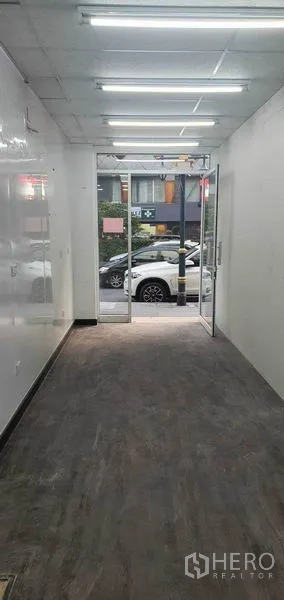 Retail Space for rent in Khlong Toei, Bangkok - Long open-plan shop interior with ceiling strip lights facing the glass entrance.