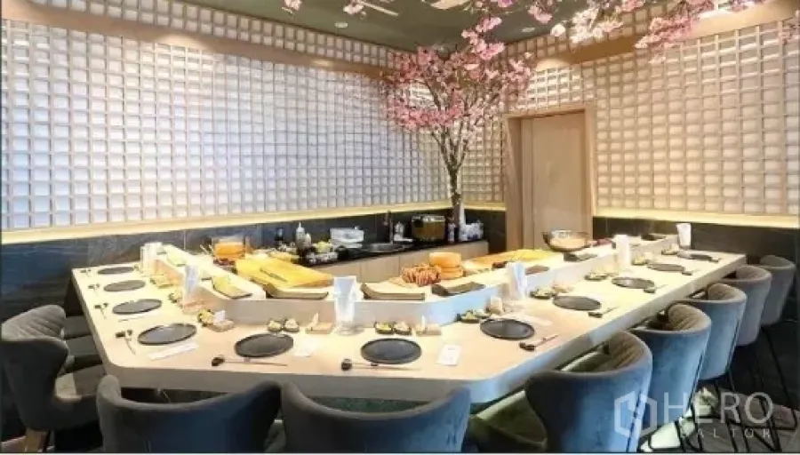 零售空间 出租 - 日式餐厅内U形寿司吧台与座位，格纹墙面与樱花装饰