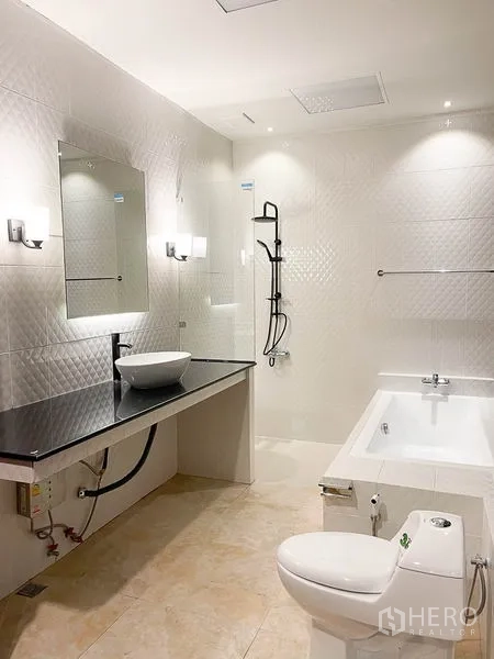 Townhouse for rent in Yan Nawa, Bangkok - Modern white bathroom with soaking tub, vessel sink on black counter and rainfall shower.