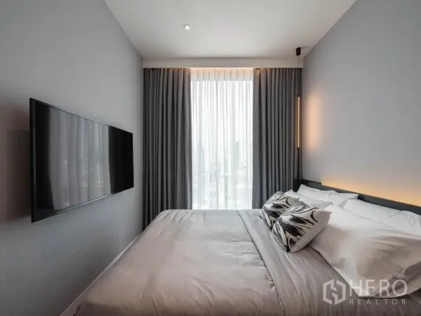 公寓 出租在Watthana, Bangkok - 主卧配壁挂电视、灰色窗帘与观景窗。