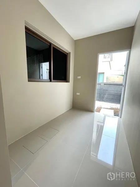 Detached House for rent in Bang Kapi, Bangkok - Utility corridor with glossy tiles leading to the rear gate.